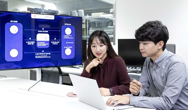 SK텔레콤과 삼성전자 연구원이 AI 기반 5G 기지국 품질 최적화 기술 실증에 대해 논의하고 있다. [제공=SKT]