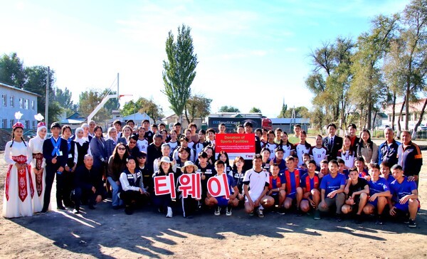 키르기스스탄 마나스 공항 인근 'At-bashi School'에서 티웨이항공 임직원 자원봉사단이 스포츠시설 설치 및 체육활동 봉사 후 학생들과 함께 기념사진을 촬영하고 있다.[제공=티웨이항공]