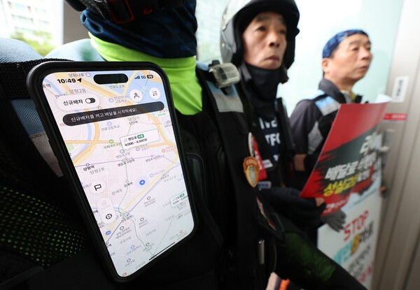배달플랫폼노동조합이 지난 8월 서울 영등포구 배달의 민족 B마트 앞에서 연 'B마트 멈춤의 날 선포 기자회견'에서 참가자들이 배달 관련 앱을 켜둔 채로 손팻말을 들고 있다. 연합뉴스