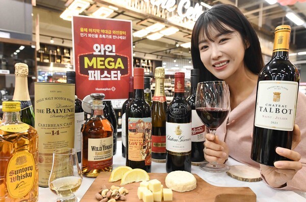 모델이 12일 서울 등촌동 ‘홈플러스 메가푸드마켓’ 강서점에서 ‘와인 메가 페스타’ 주요 상품들을 소개하고 있다. 홈플러스