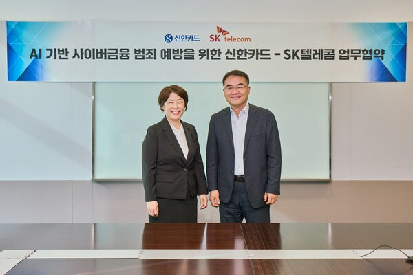 이규식 SKT AI Contact사업 담당(오른쪽)과 진미경 신한카드 고객 최고 책임자(왼쪽)가 협약서에 서명하고 기념촬영을 하고 있는 모습. [제공=SKT]