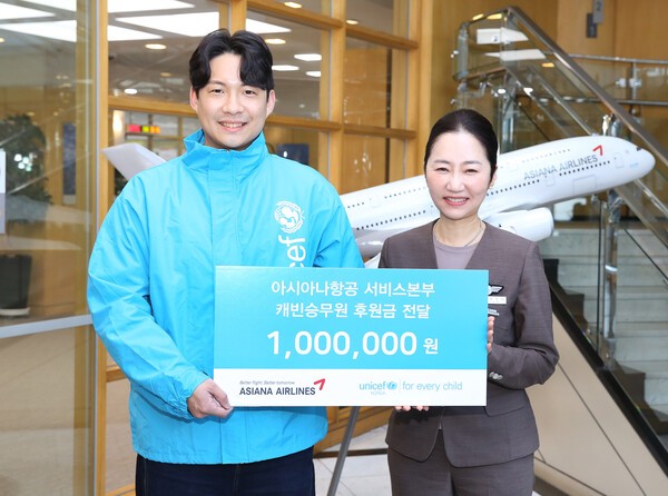 기내안전대처 사내포상자 대표 승무원이 유니세프 한국위원회 담당자에게 후원금을 전달하고 있다.[제공=아시아나항공]