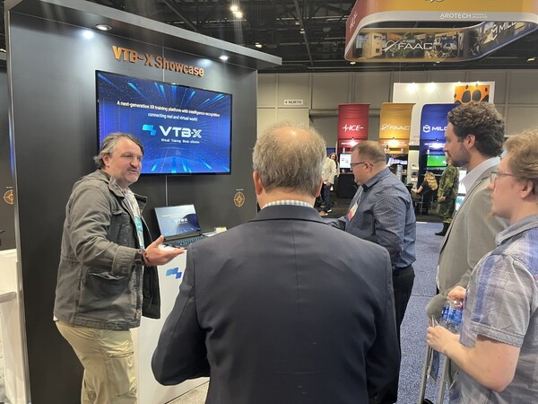 각국의 방산 업체 관계자들이 미국 ‘I/ITSEC’에서 네비웍스의 가상훈련 소프트웨어 플랫폼 ‘VTB-X’에 대해 이야기하고 있다. [제공=네비웍스]