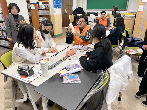 지난 19일 전남 여수 개도중학교에서 '우주항공 과학교실'에 참가한 한화에어로스페이스 임직원과 학생들이 지구 환경과 효율을 생각한 지속 가능한 항공우주선을 만들고 있는 모습. [제공=한화]