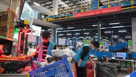 알리익스프레스 직원들이 물류창고의 번개 분류기에 상품을 넣고 있다. 알리익스프레스