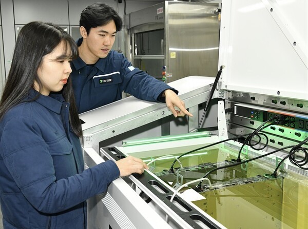 액침냉각설비에 담긴 냉각유와 서버를 테스트하고 있는 HD현대오일뱅크 직원들(HD현대오일뱅크)