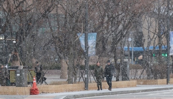 ▶ 아침 기온이 영하로 내려가며 강추위의 날씨를 보이는 16일 오전 서울 종로구 광화문광장 일대에 눈이 내리고 있다. [제공=연합]
