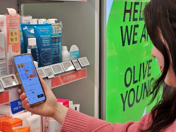 올리브영 매장에서 한 고객이 ‘전자라벨-NFC 기반 상품 탐색 서비스’를 이용하고 있는 모습. [제공=CJ올리브영]