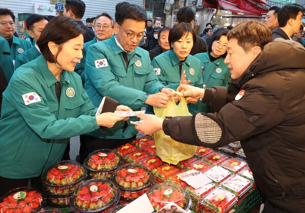최상목 대통령 권한대행 부총리 겸 기획재정부 장관이 지난 17일 서울 동작구 남성사계시장에서 과일을 사고 있다. 왼쪽부터 오영주 중소벤처기업부 장관, 최 권한대행, 송미령 농림축산식품부 장관. 연합뉴스