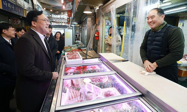 김병환 금융위원장이 설 명절을 앞둔 23일 오후 서울 종로구 전통시장인 통인시장을 방문해 고기·한과 등을 직접 구입하며 최근 전통시장 경기 및 상인들의 애로사항을 듣고 민생금융지원 방안에 대해 이야기를 나눴다.[금융위 제공]