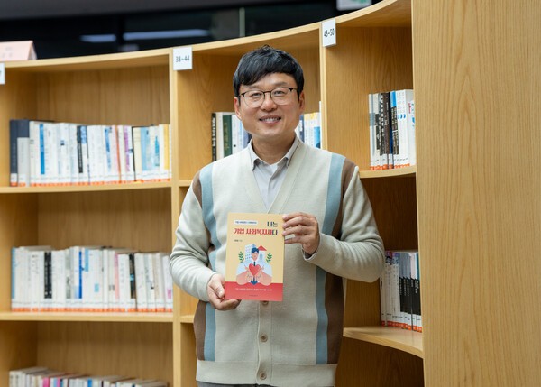 신영철 S-OIL 사회복지사가 최근 발간한 ‘나는 기업 사회복지사다’ 책을 들고 기념촬영을 하는 모습. [출처=S-OIL]