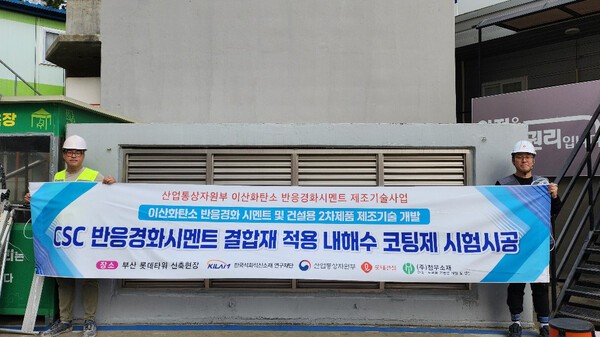 롯데건설 직원들이 부산 롯데타워 현장에서 이산화탄소 반응경화 시멘트를 활용한 코팅제를 시공하고 기념촬영을 하고 있다.[출처=롯데건설]