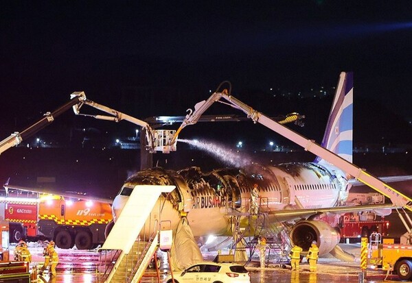 28일 오후 김해공항 계류장에서 승객 170명과 승무원 6명을 태우고 이륙을 준비하던 홍콩행 에어부산 항공기 BX391편 꼬리 쪽 내부에서 불이 나 소방대원들이 진화 작업을 하고 있다.[제공=연합]