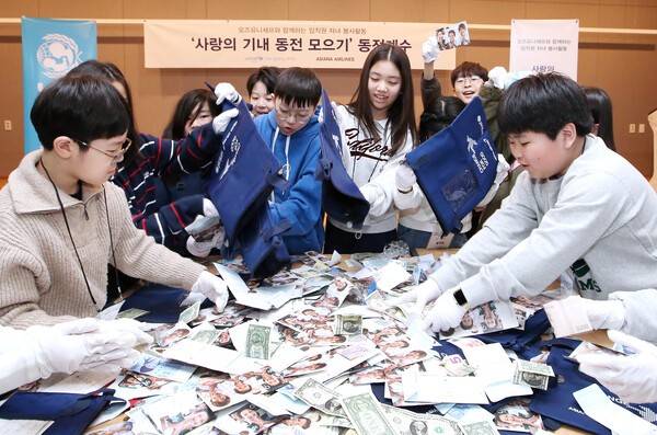 서울 강서구 아시아나항공 교육훈련동에서 임직원 자녀들이 ‘사랑의 기내 동전 모으기 캠페인’으로 모인 동전을 분류하고 있다.[출처=아시아나항공]