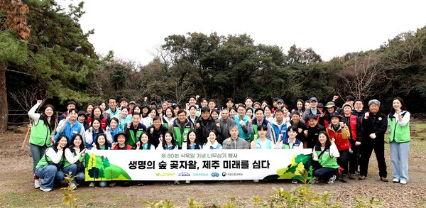 제주 곶자왈에서 식수 활동 참여자들이 단체 사진을 촬영하고 있다.[출처=진에어]