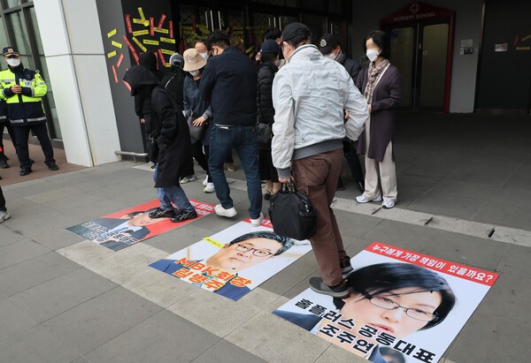 홈플러스 물품구매 전단채피해자 비상대책위원회 관계자들이 25일 서울 강서구 홈플러스 본사 앞에서 '홈플러스 공동대표와 비대위 간담회 추진결과 보고 기자회견'을 열기 전 MBK 김병주 회장과 홈플러스 공동대표의 사진을 밟고 있다.  [출처=연합뉴스]