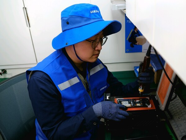 삼성전자서비스 재난복구특별서비스팀 직원이 지난달 28일 경북 의성 실내체육관에 마련된 이재민 대피소에서 산불 피해 주민의 휴대전화를 무상 수리하고 있다. [출처=삼성전자서비스]