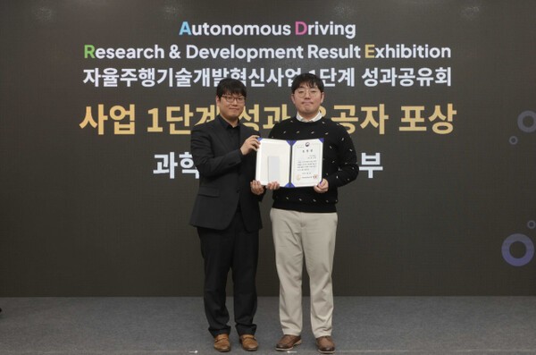 지난 4일 일산킨텍스에서 열린 ‘자율주행기술개발혁신사업’ 1단계 성과공유회에서 카카오모빌리티 홍승환 책임연구원(오른쪽)이 수상 후 과학기술정보통신부 송창종 디바이스AX혁신팀장(왼쪽)과 기념사진을 촬영하고 있다. [출처=카카오모빌리티]