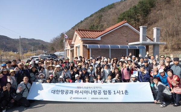 봉사활동에 참여한 대한항공·아시아나항공 양사 임직원과 가족들이 명동리 주민들과 기념사진을 촬영하는 모습.[출처=대한항공]