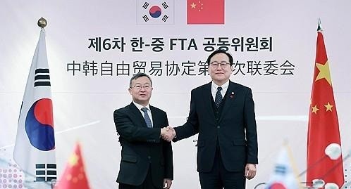 정인교 산업통상자원부 통상교섭본부장(오른쪽)이 지난해 12월 9일 '제6차 한·중 FTA 공동위원회'에서 왕셔우원 중국 상무부 국제무역 협상 대표와 악수하며 기념 촬영하고 있다. [출처=연합]