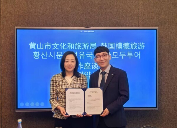 이우연 모두투어 상품본부장(오른쪽)과 팡잉 황산시 문화여유국 부국장이 지난 23일 중국 환산시 문화여유국 회의실에서 전략적 업무협약(MOU)을 체결하고 기념촬영을 하고 있다. [출처=모두투어]