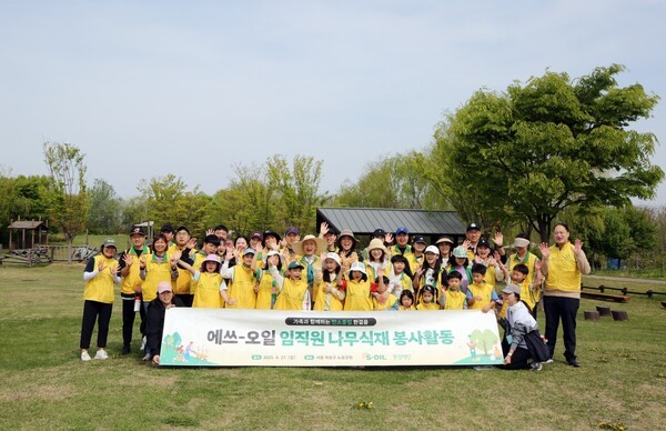 에쓰오일 나무심기 봉사활동에 참여한 임직원들이 나무를 식재하고 기념촬영을 하고 있다. [출처=에쓰오일]