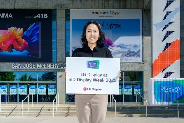 LG디스플레이 직원이 12일(현지시간) 세계 최대 디스플레이 전시회 'SID 2025'가 열리는 미국 새너제이 맥에너리컨벤션센터 앞에서 참가 소식을 알리고 있다. [출처=LG디스플레이]