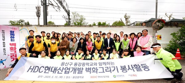 HDC현대산업개발은 15일 도시정비부문 임직원과 용산구 주민, 용강중학교 학생 등 40여 명과 함께 서울시 용산구 용강중학교 일대 담장 벽화그리기 봉사활동을 진행했다.(앞에서 두 번째 줄 오른쪽 다섯 번째부터)권충환 용강중학교장, 강경민 HDC현대산업개발 도시정비부문장, 박희영 용산구청장)[출처=HDC현대산업개발]