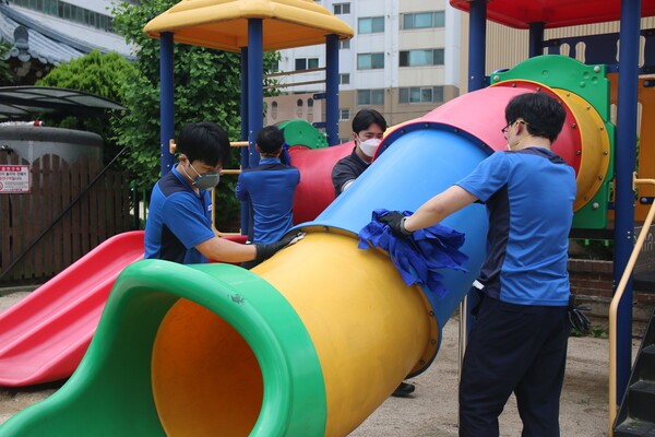 금호타이어 임직원 자원본사자들이 놀이터를 덮인 분진을 청소하고 있다. [출처=금호타이어]