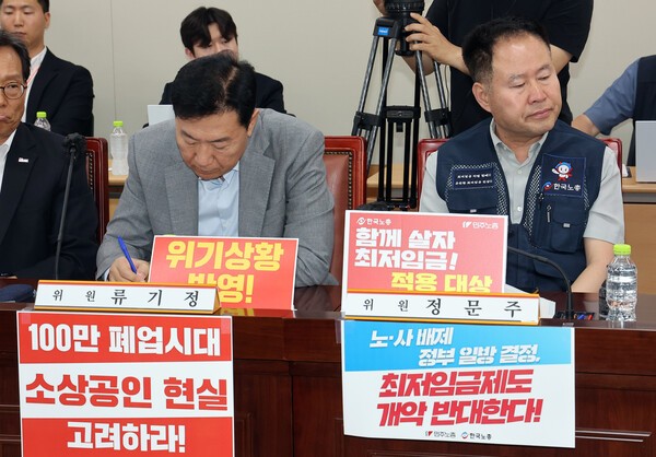 최저임금위원회 사용자위원인 류기정 한국경영자총협회 전무(왼쪽)와 근로자위원 정문주 한국노총 중앙연구원장이 지난 10일 정부세종청사에서 열린 최저임금위원회 제4차 전원회의에서 나란히 자리하고 있다. [출처=연합]