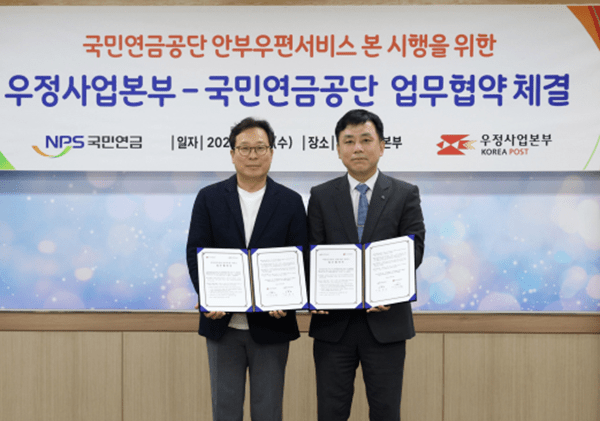 박인환 우정사업본부 우편사업단장(왼쪽)과 정태규 국민연금공단 연금이사가 18일 우정사업본부 회의실에서 업무협약을 맺고 있다. [출처=우정사업본부]