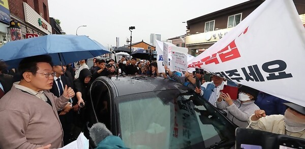 지난 5월 당시 이재명 대선 후보가 제3차 골목골목 경청투어로 경북 고령군을 방문해 대구에서 온 시민들의 지역주택조합 관련 하소연을 경청하고 있는 모습.[출처=연합]