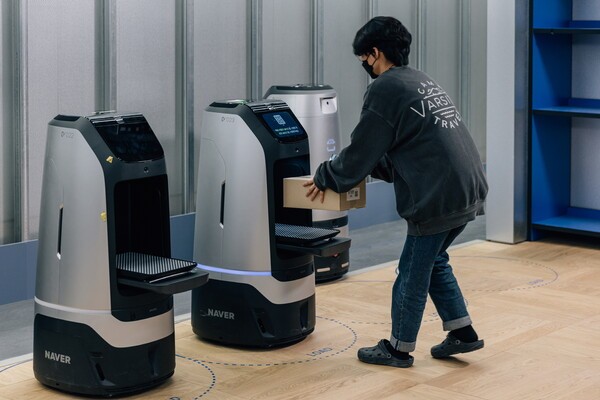 네이버의 딜리버리 로봇에서 직원이 배송물을 꺼내고 있다. [출처=네이버]