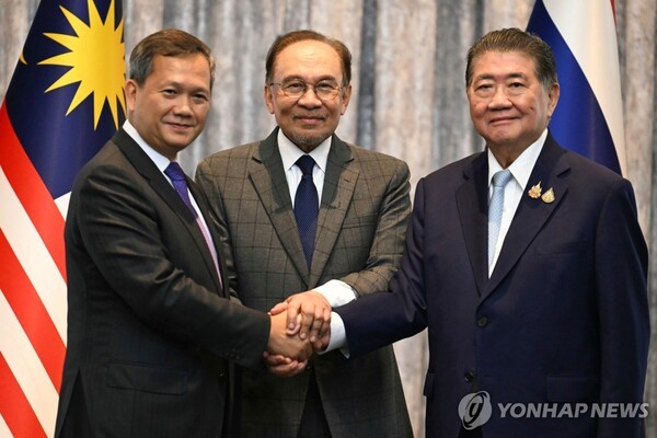 28일(현지시간) 말레이시아 행정수도 푸트라자야에서 훈 마네트 캄보디아 총리(사진 왼쪽)와 태국 총리 권한대행인 품탐 웨차야차이 부총리 겸 내무부 장관(오른쪽)이 휴전에 합의한 뒤 회담을 중재한 안와르 이브라힘 말레이시아 총리(가운데)와 함께 손을 잡고 있는 모습 [사진제공=연합뉴스]