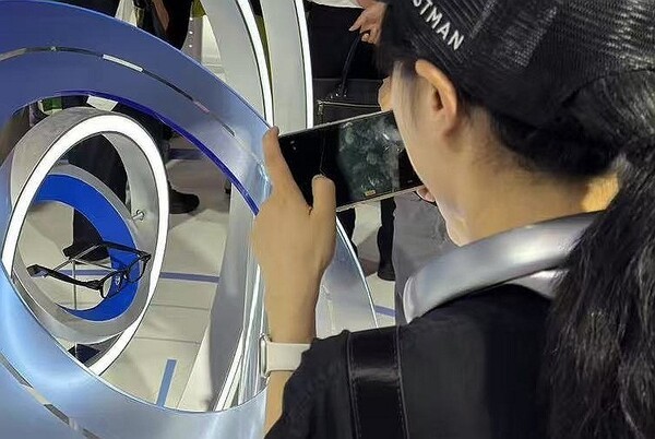 27일 중국 상하이에서 열린 '2025 세계인공지능대회(WAIC)' 전시장에서 한 관람객이 알리바바 AI 안경 '쿼크' 살펴보고 있다. [출처=연합뉴스]