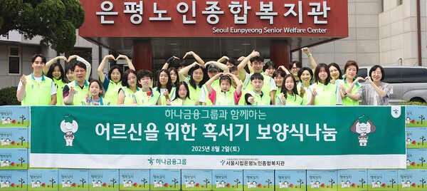 하나금융그룹은 지난 2일 서울 은평구에 위치한 서울시립은평노인종합복지관에서 어르신들의 건강한 여름나기를 지원하는 '혹서기 보양식 나눔' 봉사활동을 실시했다. 이날 봉사활동에 참여한 하나금융그룹 임직원과 임직원 가족들이 기념촬영을 하고 있다. [출처=하나금융그룹]