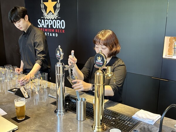 삿포로 프리미엄 비어스탠드에서 전문 탭퍼가 맥주를 따르고 있다. [출처=EBN]