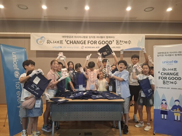 아시아나항공과 대한항공 임직원 자녀들이 ‘사랑의 기내 동전 모으기 캠페인’으로 모인 동전을 계수하는 봉사 활동을 하고 있다.[출처=아시아나항공]