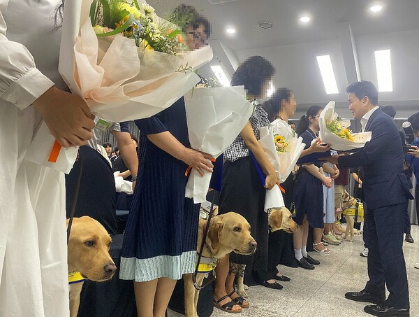삼성화재 안내견학교가 32주년을 맞은 가운데 안내견 8마리가 김예지 국민의힘 의원 등 새 가족을 만났고 은퇴견 5마리가 새로운 시작을 알렸다. 이문화 삼성화재 사장이 이들을 축하하며 꽃다발과 감사패를 전했다. [출처=EBN 김남희 기자 ]