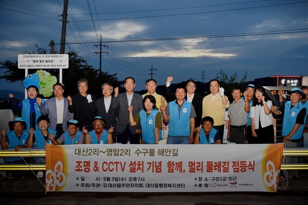 한화토탈에너지스가 3일 대산읍 수구물로 해안 산책로에서 ‘함께, 멀리 둘레길’ 점등식을 개최했다. 지역 관계자들과 회사 임직원이 점등을 축하하고 있다. [출처=한화토탈에너지스]