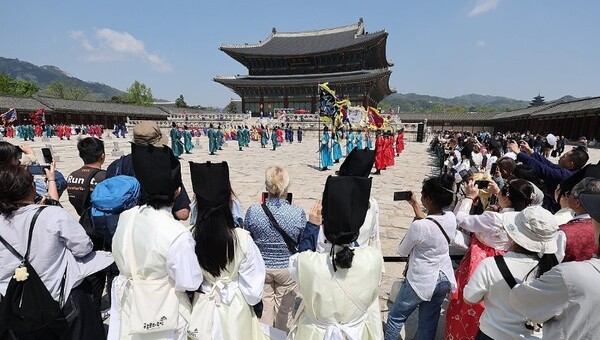 시민 및 외국인 여행객들이 지난 4월 말 서울 종로구 경복궁에서 궁중 일상을 재현한 ‘시간여행, 세종’ 공연을 관람하고 있다. [출처=연합뉴스]