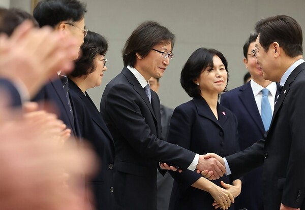 이재명 대통령이 15일 용산 대통령실에서 열린 임명장 수여식에 참석하며 주병기 공정거래위원장에게 축하 인사를 하고 있다[출처=연합]