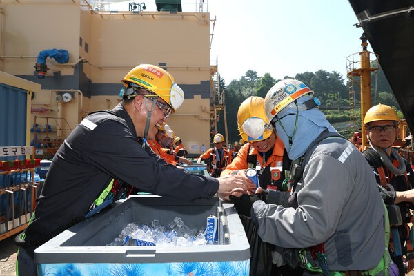 한화오션 김희철 대표이사(왼쪽)가 거제사업장 1도크 주변에서 근로자들에게 시원한 음료를 건네주고 있다.[출처=한화오션 ]