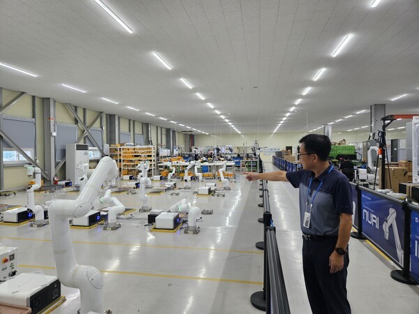 이재천 뉴로메카 로봇생산부문장이 12일 포항 공장에서 에이징되고 있는 협동로봇을 가리키고 있다. [출처=진운용 기자]