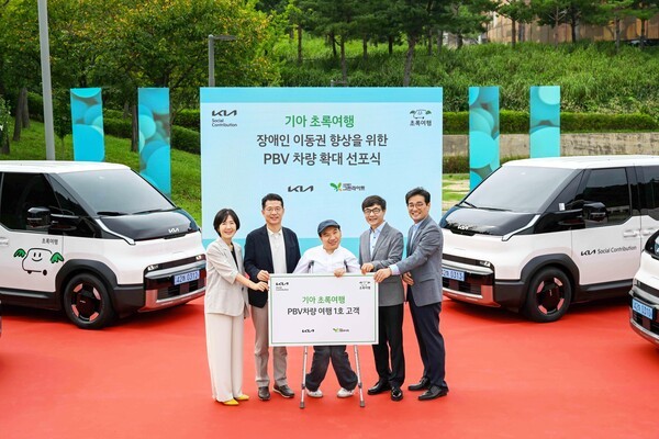 기아 지속가능경영실장 이덕현 상무(왼쪽 두번째), 사단법인 그린라이트 이재강 회장(왼쪽 네번째) 등 주요 관계자들이 PV5 여행 1호 고객과 기념 촬영을 하고 있는 모습 [출처=기아]