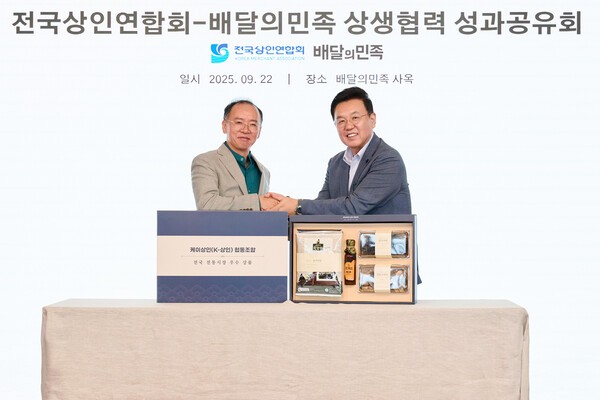 윤석준 우아한형제들 총괄사장(오른쪽)과 이충환 전국상인연합회 회장이 지난 22일 서울 송파구 롯데월드타워 사옥(더큰집)에서 ‘상생협력 성과공유회’를 기념해 사진 촬영을 하고 있는 모습. [출처=우아한형제들]