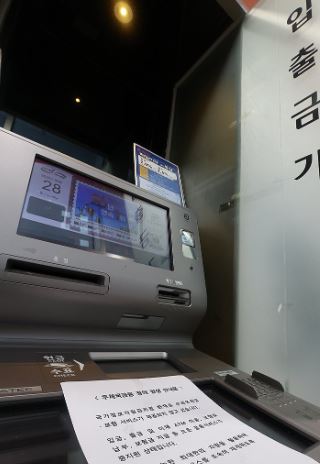 대전 국가정보자원관리원(국정자원) 전산실 화재로 우편ㆍ금융 서비스 차질이 생긴 가운데 28일 서울 시내 한 우체국 현금자동입출금기(ATM)에 관련 안내문이 붙어있다. [출처=연합]
