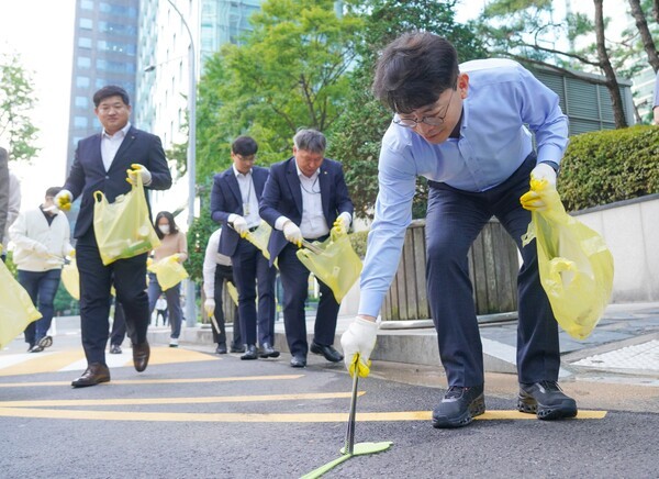지난 29일 여의도 한강공원 일대에서 진행된 ‘임직원 플로깅 데이’에 참여한 KB금융지주 임직원이 환경 정화 활동을 하고 있다. [출처=KB금융]