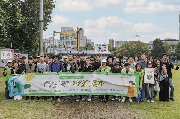 플로깅 환경봉사활동 ‘시간을 걷다, 자연을 줍다’ 행사 기념 단체 사진을 촬영하고 있는 GM 한국사업장 임직원들과 산곡노인문화센터 회원들 [출처=지엠한마음재단코리아]