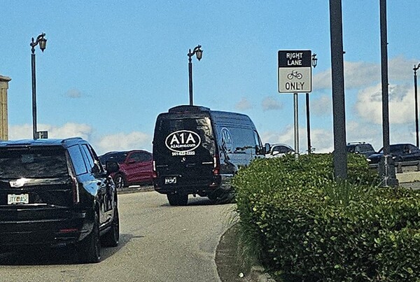 한국 기업 총수들과 이들을 트럼프 대통령과의 골프 회동에 초청한 손정의 일본 소프트뱅크 회장이 탑승한 것으로 추정되는 검정 리무진 버스가 18일(현지시간) 골프 경기를 마치고 팜비치 섬으로 건너가는 모습. [출처=연합]